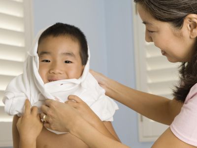 Mother helping son put on shirt