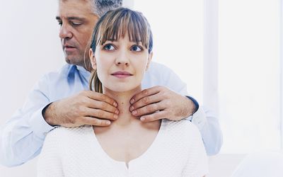 Doctor Examining Patients Thyroid