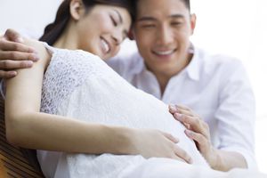 Expecting couple with hands on pregnant belly