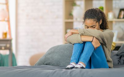 Teenager curled up looking sad