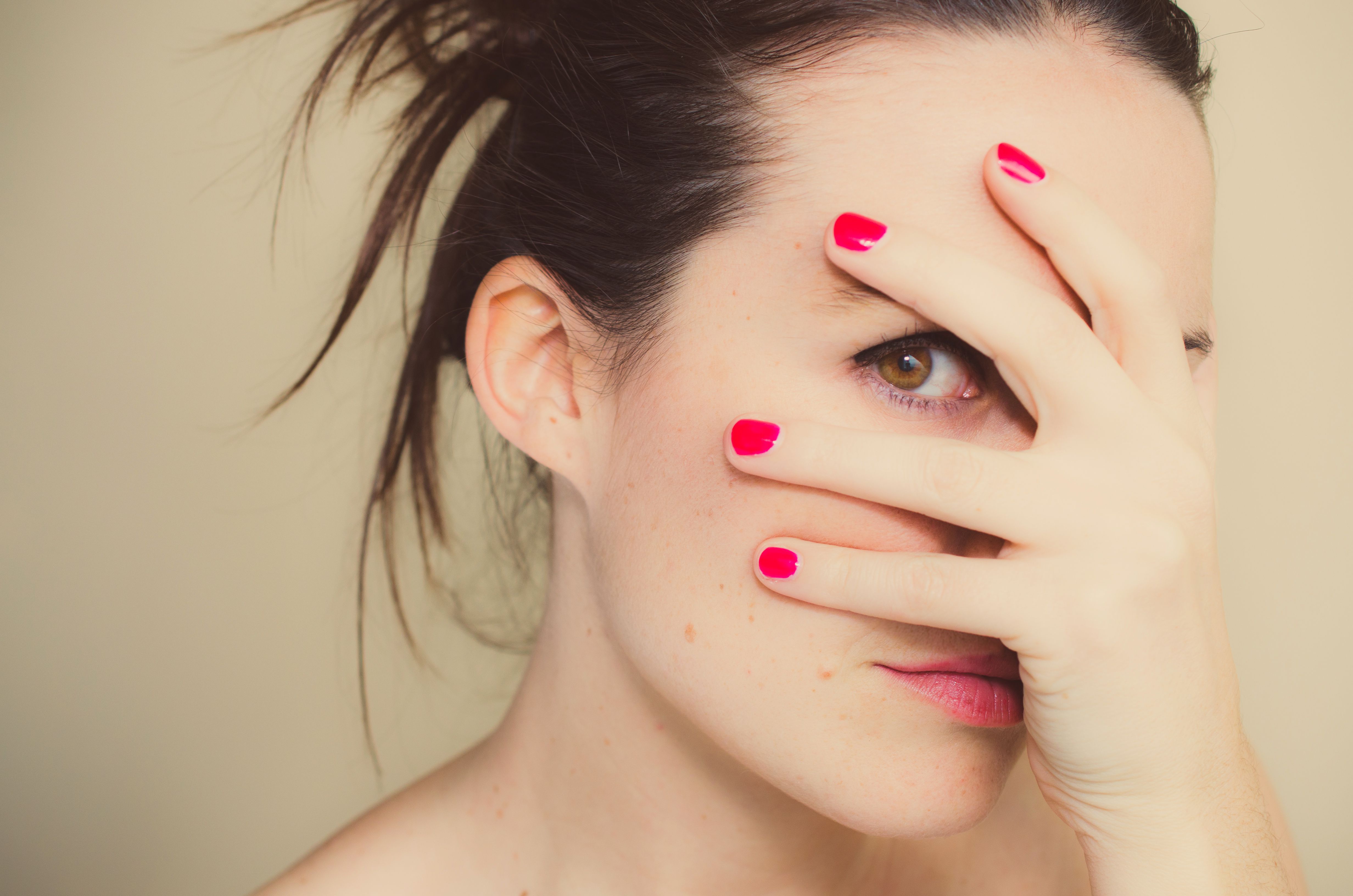 女人捂着脸，手上涂着红色的指甲油，象征着内疚