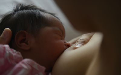 一位母亲在医院给刚出生的婴儿喂奶