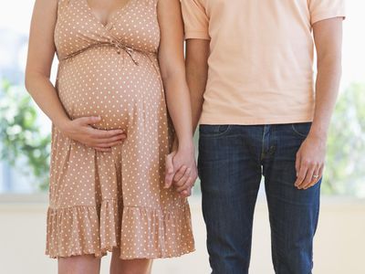 Pregnant woman holding partner's hand
