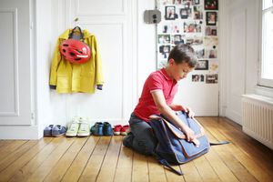 boy fastening latch on school bag