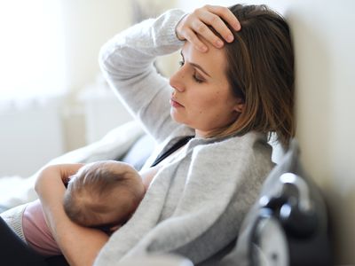 breastfeeding person touching head