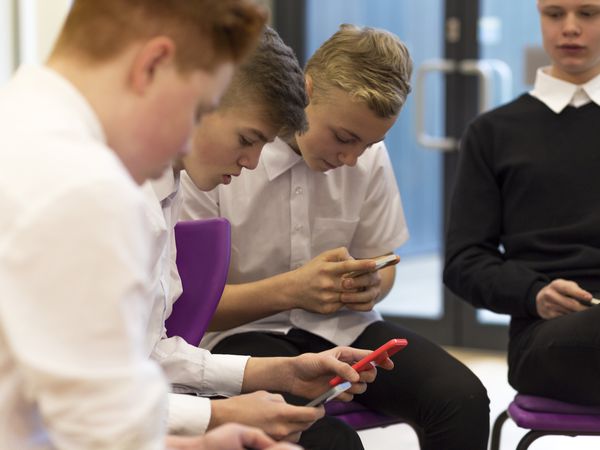 Boys in a classroom using smartphones