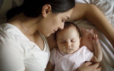 mom and baby lying on the bed