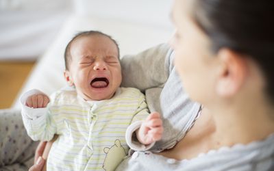 母亲抱着哭泣的婴儿