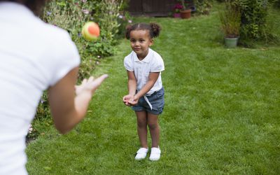 学龄前女孩在外面玩球＂width=