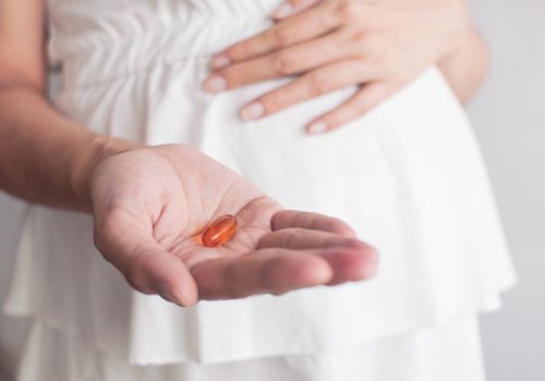 pregnant woman holding prenatal vitamins