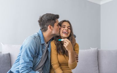 Happy couple looking at pregnancy test.