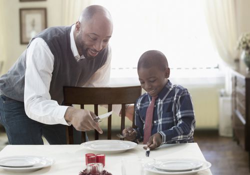 Father and son setting holiday table