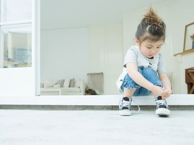 Girl learning to tie her shoelaces