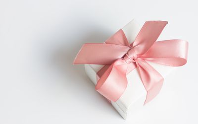 白色桌子上的礼盒上系着粉红色的丝带