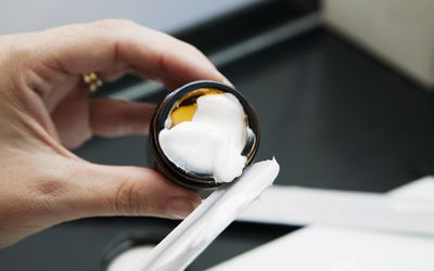 Pharmacist putting ointment in a jar