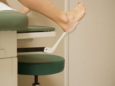 Woman with her feet in stir-ups at gynecologist office