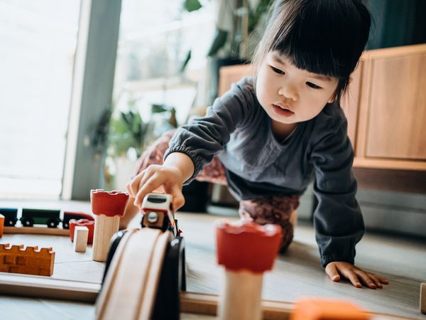 KiwiCo Review girl playing with wooden toy train in the living room at home