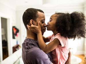 a child kissing their parent on the nose