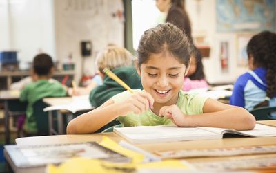 second grade girl in classroom smiling