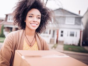 college-aged young woman holding a cardboard box