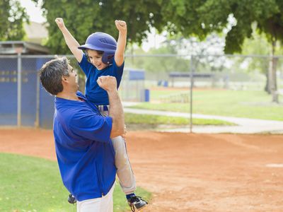 Good sports parent - dad and son celebrating at baseball game