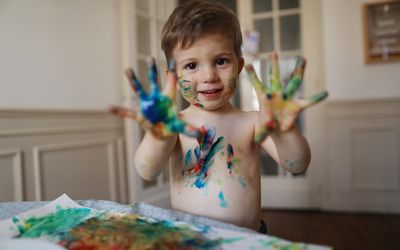little boy using finger paints