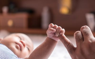 婴儿用足底反射抓父母的手指