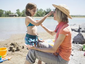 young grandmother at the beach with a granddaughter