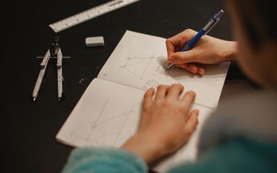 teen doing math problems in a notebook