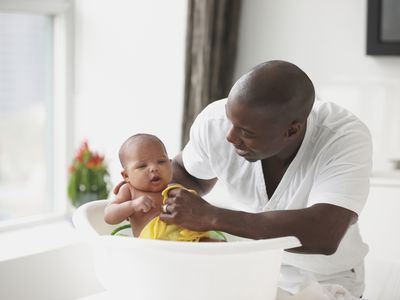 Father bathing infant son