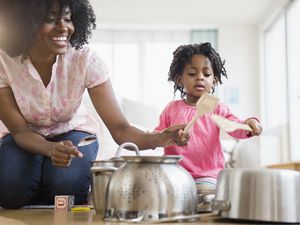 Mother and daughter playing with pots and pans