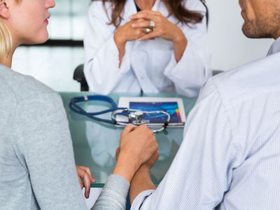 Doctor discussing with a couple during consultation.