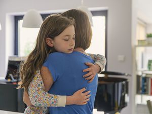 Young girl getting a big cuddle from her mum