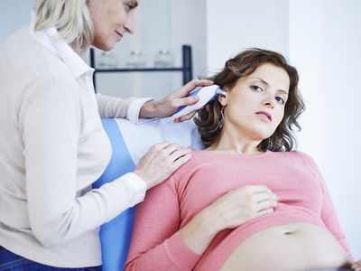 Pregnant woman having her temperature taken