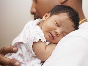 Father holding newborn daughter