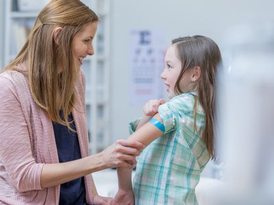 Girl has bandage on her arm after getting a vaccination