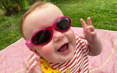 Baby wearing 100% UV protection sunglasses with a strap