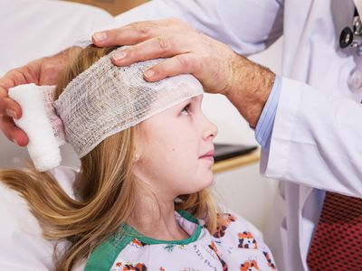 Doctor wrapping child's head.