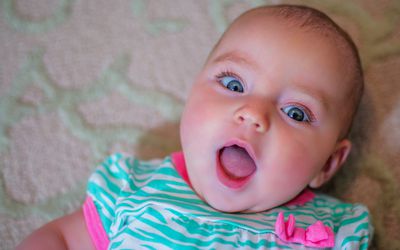 Overhead portrait of wide eyed baby girl