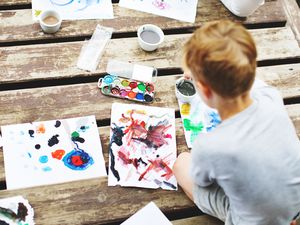 boy painting outside on deck