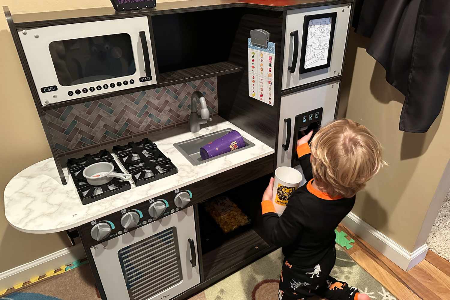 Kid playing with Melissa & Doug Wooden Chef’s Pretend Play Kitchen