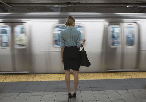一个女人站在地铁站台上