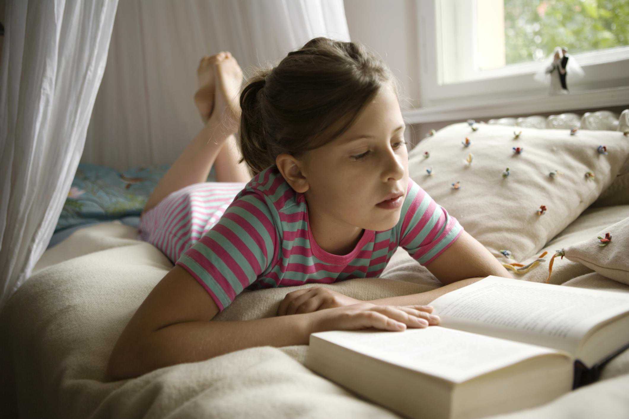 小女孩在床上看书