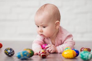 小婴儿趴在肚子上玩彩蛋，寓意捐卵者的受孕和选择