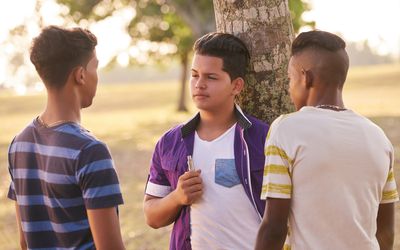 three teen boys discussing vaping