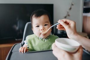 婴儿坐在高脚椅上进食