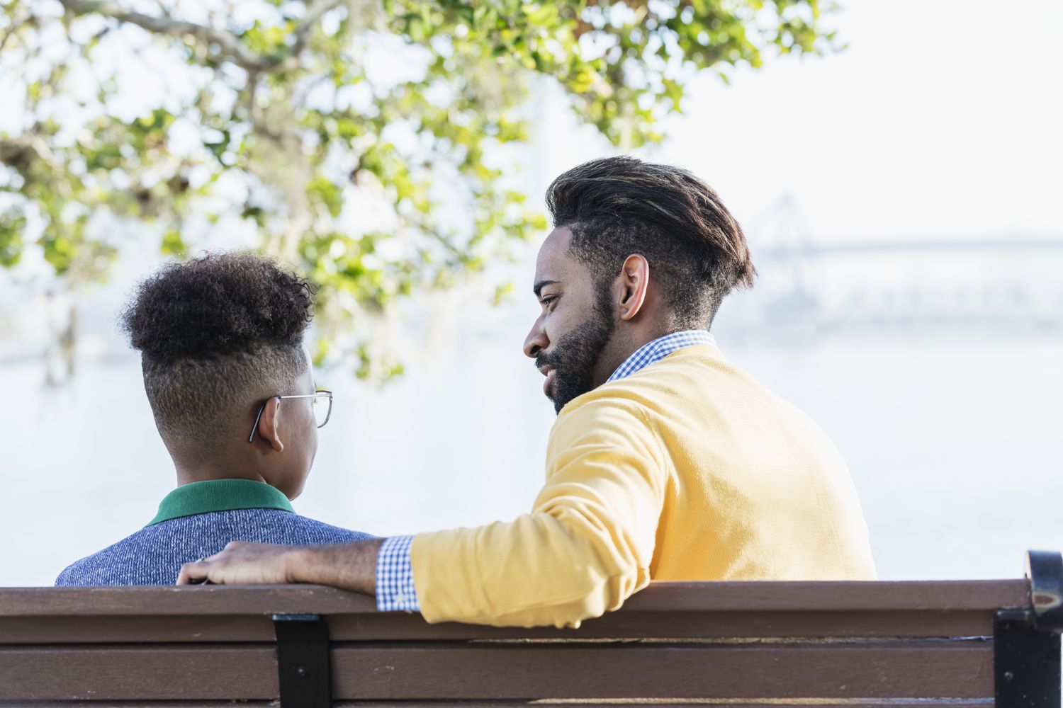 parent and child sitting on a bench and talking