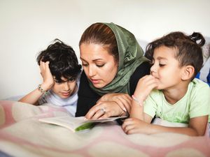 mom-reading-to-her-kids-on-bed