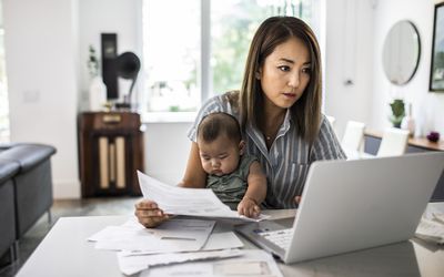 Woman works with infant baby in her lap