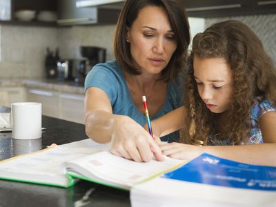 Homeschool parent helping daughter with her studies